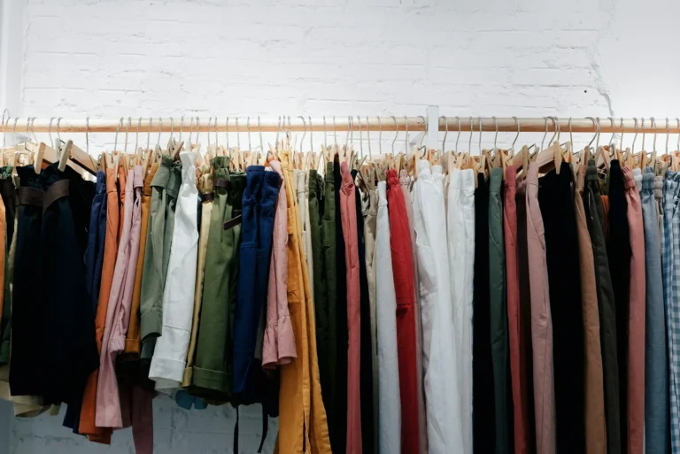Clothes grouped on a rack by type and colour