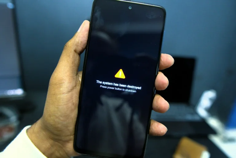 A hand holding a phone displaying a warning message on screen