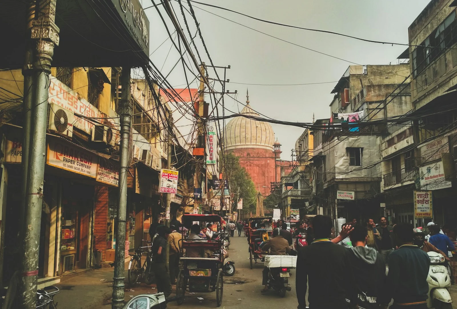 Busy Delhi street lined with small shops and traffic