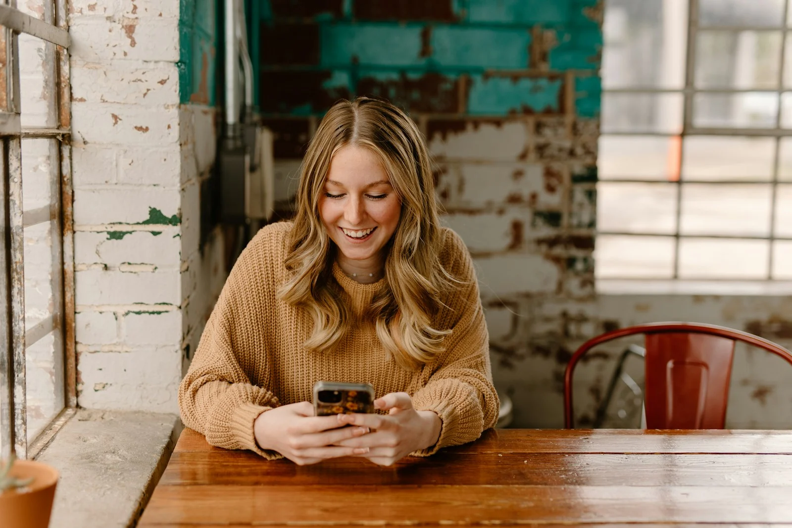 Woman at a cafe table reading a quick answer on her phone