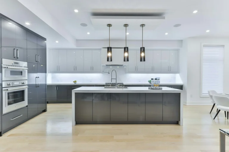 Modern modular kitchen with grey cabinets, a white island and pendant lights