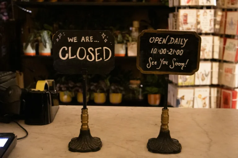 Shop counter with a Closed sign and an Open Daily sign showing the opening hours