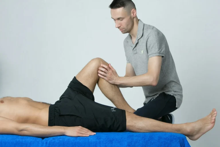Physiotherapist examining a patient's knee on a treatment table