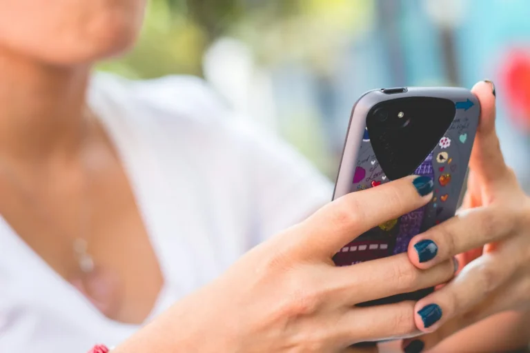 Woman typing on her smartphone, as a customer leaving a review would