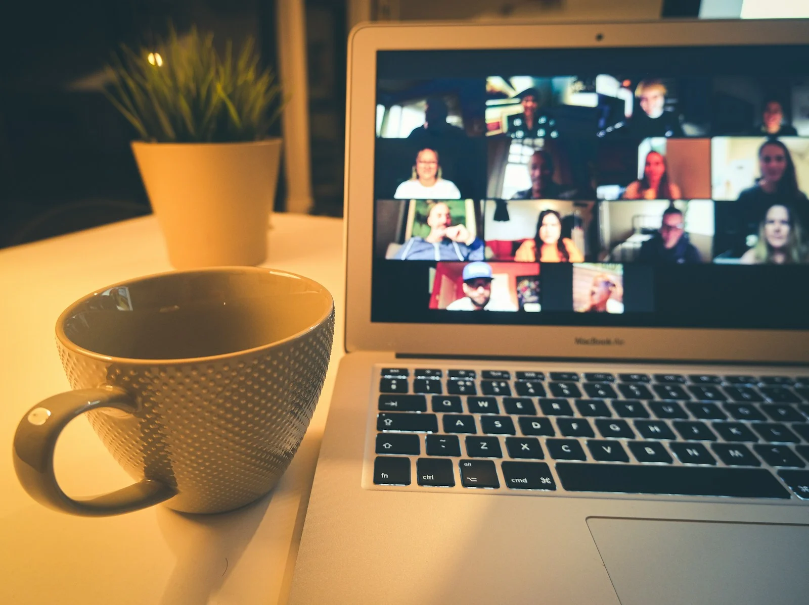 A video call open on a laptop beside a coffee cup, the way day-to-day client work runs