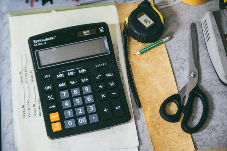Calculator and office supplies on a desk for working out a monthly marketing budget