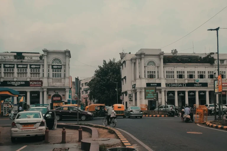 Traffic passing white colonnaded buildings in central New Delhi