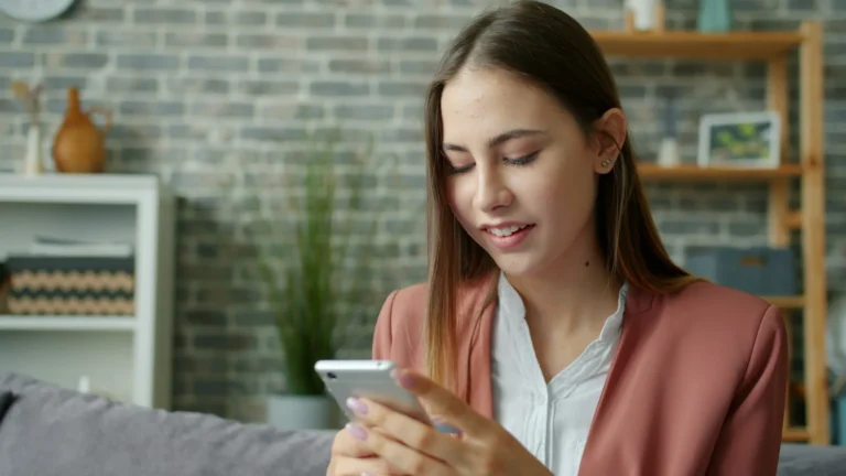 Woman browsing a website on her smartphone while sitting on a couch