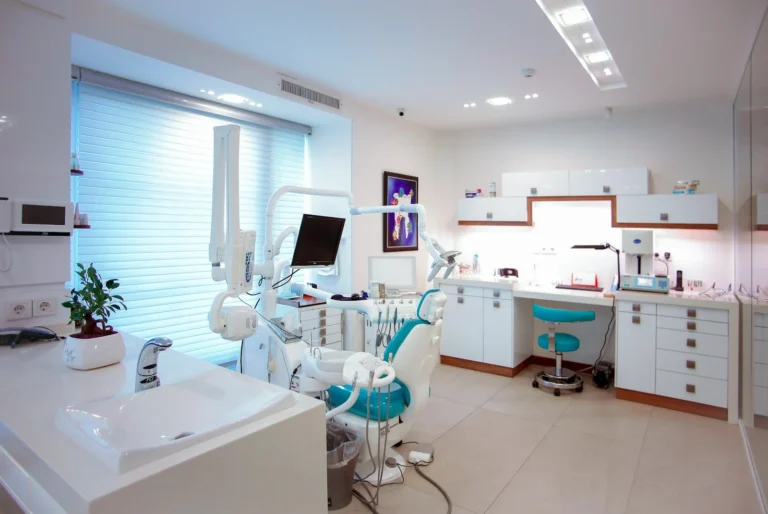 Bright modern dental clinic treatment room with a dental chair and equipment