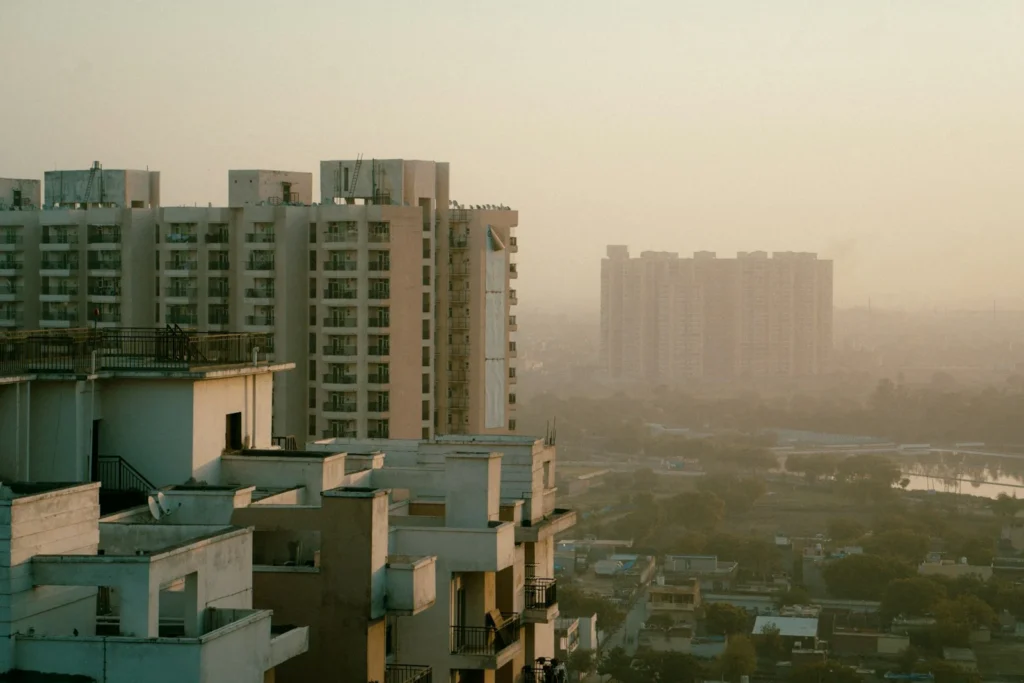 High-rise apartment towers in hazy afternoon light over an NCR suburb