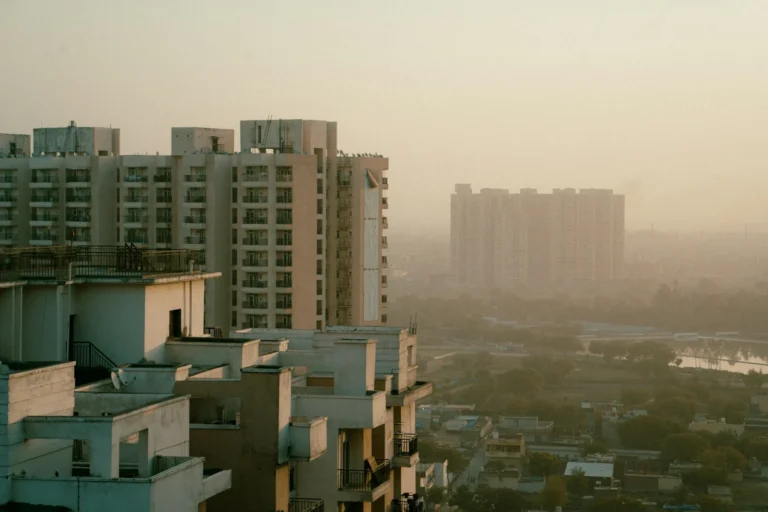 High-rise apartment towers in hazy afternoon light over an NCR suburb