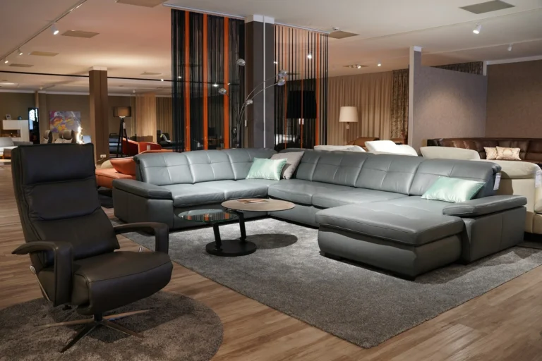 Furniture showroom floor with a grey sectional sofa and a leather recliner