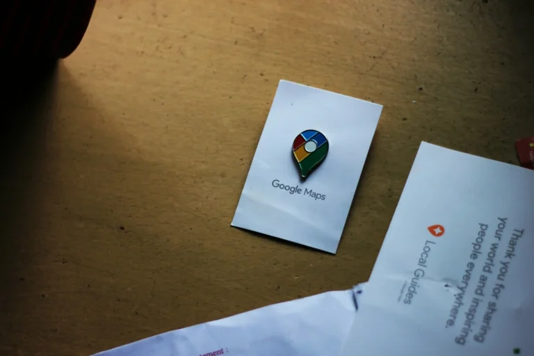 Google Maps pin card lying on a desk next to a Local Guides note