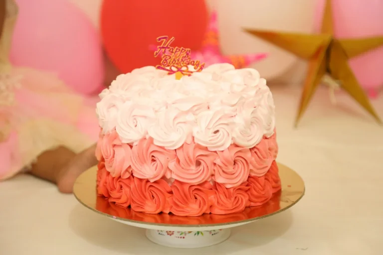 Pink and white rosette birthday cake on a cake stand