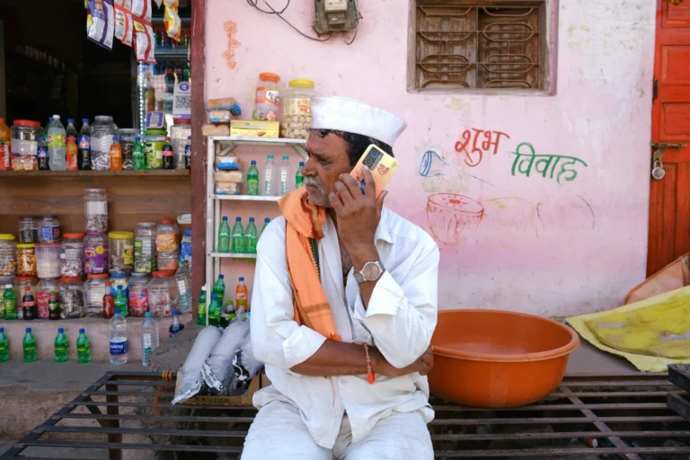 Shopkeeper taking a phone call outside his general store