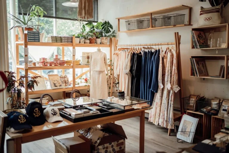 Small clothing boutique with dresses on racks and accessories on a wooden table