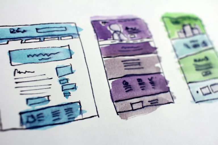 Watercolour wireframe sketches of three website page layouts