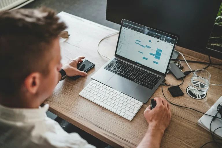 A person working on a laptop at a desk, checking a website dashboard