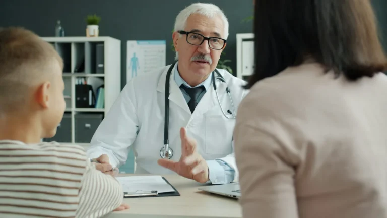 Doctor explaining a diagnosis to a mother and her young son in a clinic office