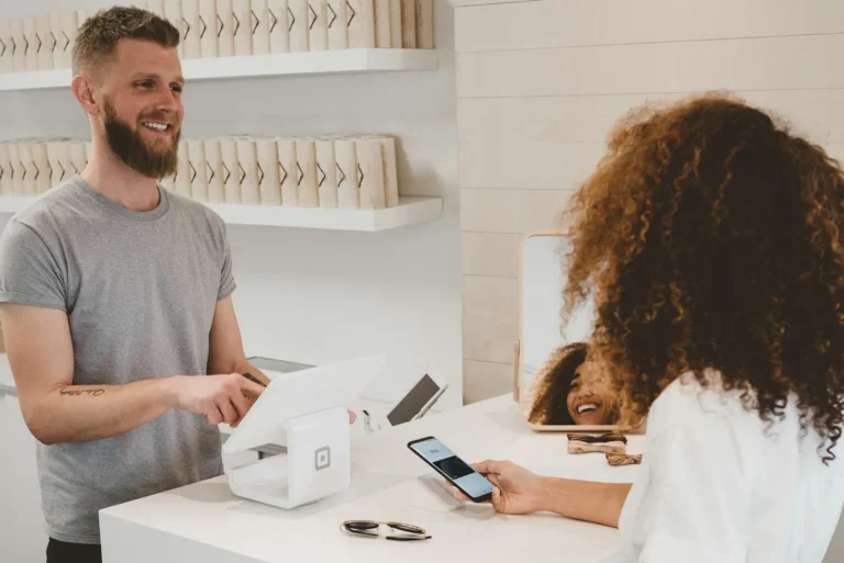 Smiling shop owner serving a customer at the counter