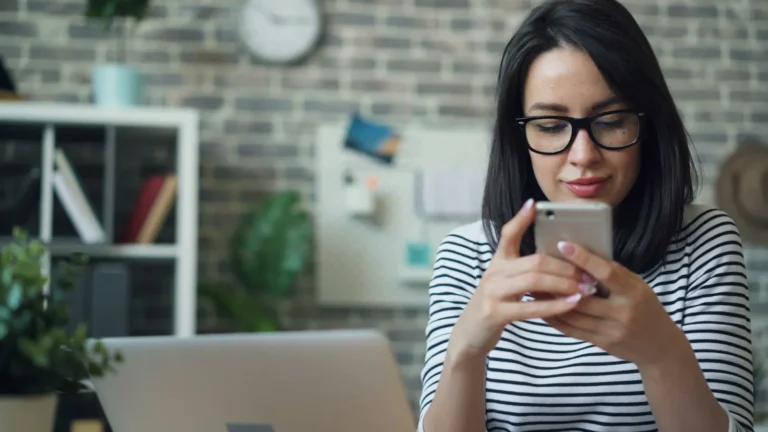 Woman typing a reply to a customer review on her phone