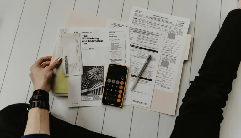 Tax forms, a pen and a phone calculator on a table