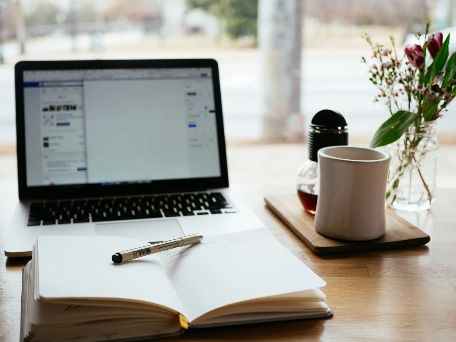 Digital marketing blogs drafted beside a laptop with an open notebook and pen