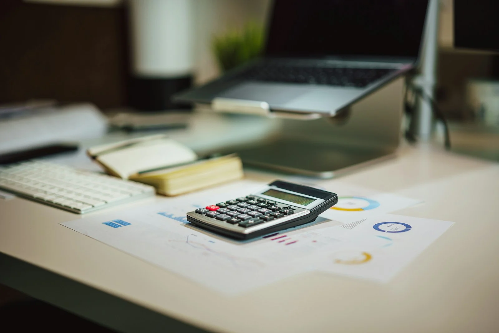 Digital marketing packages costed on a desk with a calculator, printed charts and a laptop