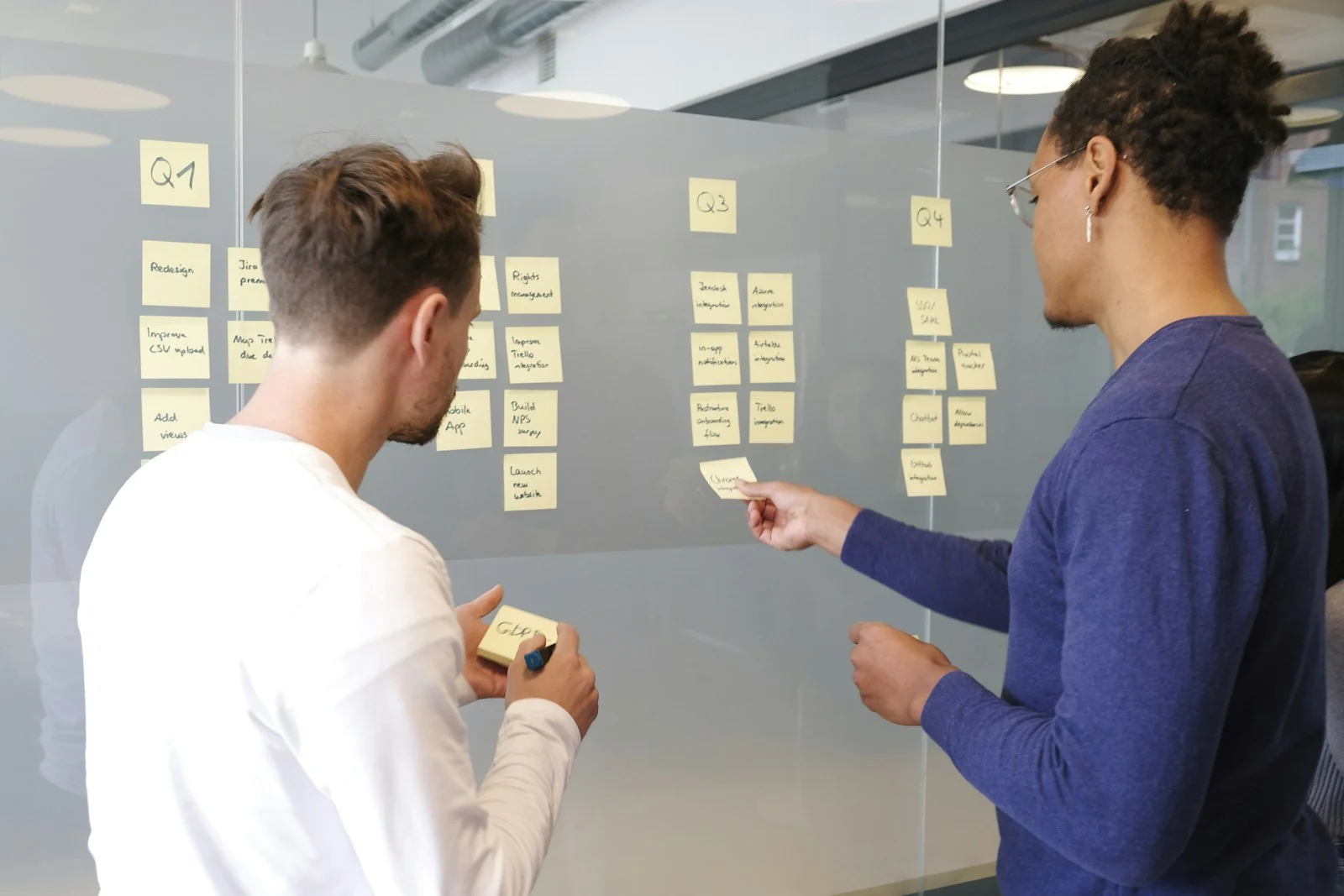 Digital marketing process planned on a glass wall with sticky notes